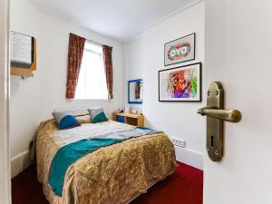 ロンドンにあるBoston Court Hotelのベッドルーム1室(ベッド1台付)、窓、ドアが備わります。