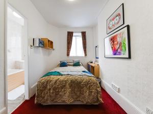a small bedroom with a bed and a bathroom at OYO Boston Court Hotel in London