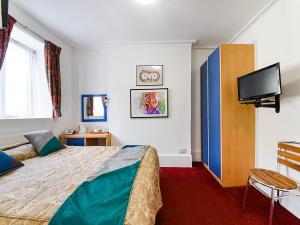 a bedroom with a bed and a flat screen tv at Boston Court Hotel in London