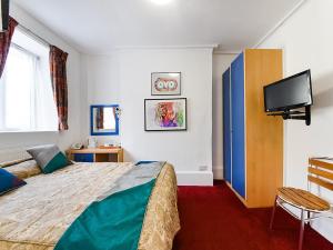 una camera con letto e TV a schermo piatto di OYO Boston Court Hotel a Londra