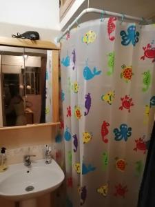 a bathroom with a shower curtain with fish on it at BLUE SEA. TONY FRÍAS. LAS ERAS. ARICO - TENERIFE. in Arico el Nuevo