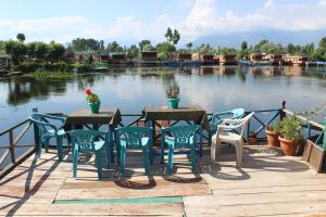 a table and chairs on a dock next to the water at Young Bombay Heritage Houseboats in Srinagar