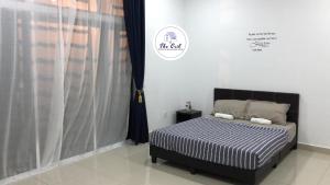 Schlafzimmer mit einem schwarzen und weißen Bett und einem Fenster in der Unterkunft The Crib @ Desaru in Desaru