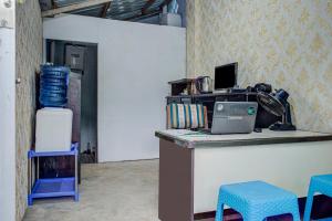 um escritório com uma secretária com um computador portátil e cadeiras em OYO 3266 Alifah Residence Syariah em Padang