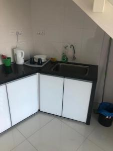 eine Küche mit weißen Schränken und einem Waschbecken in der Unterkunft The Ceo Suites in Bayan Lepas