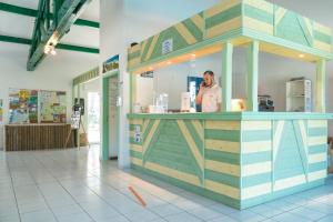 a man talking on a cell phone behind a counter at Résidence Odalys Bleu Ocean in Moliets-et-Maa +25 photos