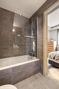 een badkamer met een douche en een bad bij Whistler Lodge by Alpine Residences in Courchevel