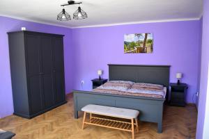 1 dormitorio con cama y pared púrpura en PENSION NA BORŮVKOVÉM VRŠKU, en Bujanov