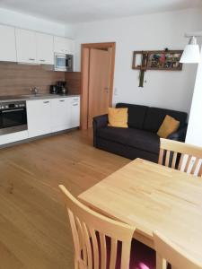 ein Wohnzimmer mit einem Tisch und einem schwarzen Sofa in der Unterkunft Appartement Alpenglück in Aich