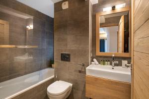 een badkamer met een wastafel, een toilet en een bad bij Whistler Lodge by Alpine Residences in Courchevel