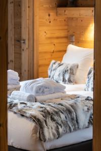Dos camas en una habitación con una manta. en Whistler Lodge by Alpine Residences, en Courchevel