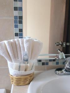 a basket of towels sitting on top of a sink at Hotel San Miguel, en el Centro - Desayuno Gratis in Tuxtla Gutiérrez