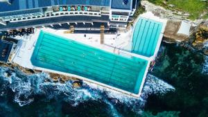 een uitzicht op een gebouw naast de oceaan bij The Blue Hotel Bondi in Sydney