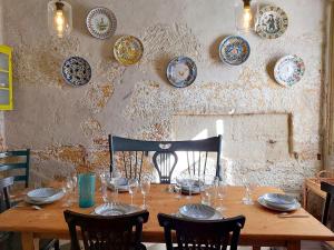 una mesa de madera con sillas y platos en la pared en Sant Roc en Mahón