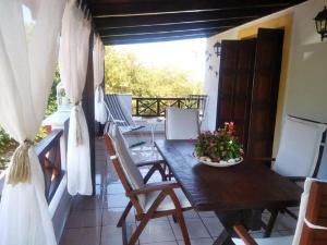 a wooden table and chairs on a balcony at Kalogirou Stone House in Limnionas