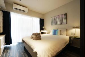 pokój hotelowy z łóżkiem z ręcznikami w obiekcie Real Life Meguro River w Tokio