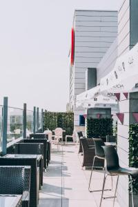 un patio avec des chaises et des tables dans un bâtiment dans l'établissement Ramada by Wyndham Constanta, à Constanţa