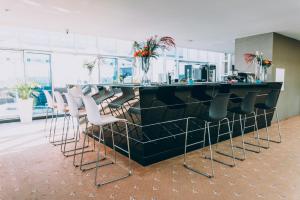 um bar num escritório com cadeiras e um balcão em Ramada by Wyndham Constanta em Constança