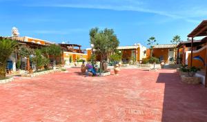 a courtyard with two people sitting on a bench at Residence La Conchiglia in Lampedusa