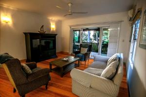 a living room with two couches and a table at Red Coconut Self-Catering in Mahe