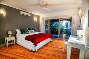 a bedroom with a bed and a desk and a window at Red Coconut Self-Catering in Mahe +44 photos