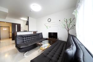 - un salon avec un canapé en cuir et une télévision dans l'établissement EX Itoman Apartment 503, à Teruya