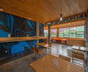 a restaurant with tables and a mural on the wall at DJourney Hotel Lembang by Escotel in Bandung
