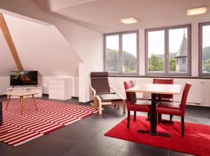 a living room with a table and chairs and a tv at Luxusapartment Burgschänke in Kaiserslautern