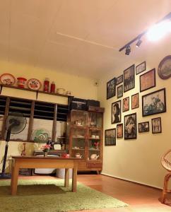 ein Wohnzimmer mit einem Tisch und Bildern an der Wand in der Unterkunft Once In Peninsula Guesthouse by Nestcove in Malakka