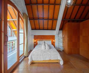 a bedroom with a bed in a room with windows at DJourney Hotel Lembang by Escotel in Bandung