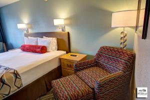 a hotel room with a bed and a chair at Old Town Inn in Florence