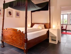 - une chambre avec un lit à baldaquin et une table dans l'établissement Luxusapartment Burgschänke, à Kaiserslautern