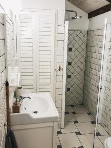 a white bathroom with a sink and a shower at Karak Chalet in Izvoare
