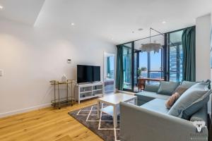 a living room with a couch and a tv at KOZYGURU FORTITUDE VALLEY HOLIDAY STYLE 2 BED APT FREE PARKING QFV211-1601 in Brisbane