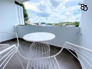 d'une table et de chaises blanches sur un balcon avec fenêtre. dans l'établissement The 83 Betong GuestHouse, à Betong