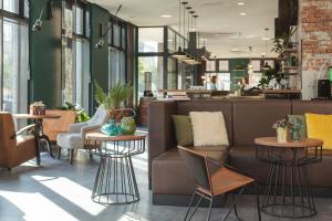 een lobby met een bank en tafels en stoelen bij the niu Bricks in Hamburg