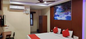 a bedroom with a bed with red pillows at Kumaran Millenium Residency in Vellore
