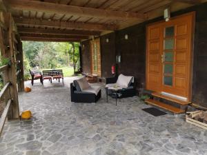 a screened in porch with chairs and a table at Vetrovi šumijo II in Kapele