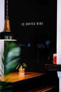 Le Coffee Ride Cycling Cafe في ستافيلو: يوجد خزاف نباتي على طاولة خشبية