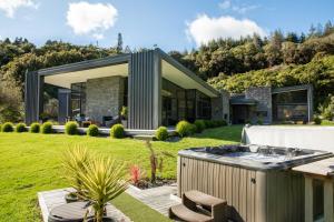 a house with a hot tub in a yard at The Jewel of Akatarawa in Upper Hutt