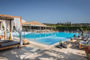 a large swimming pool with chairs and a building at Avithos Resort Hotel in Svoronata