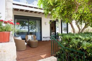 a house with a wooden deck with glass doors at Artemis Village Apartments & Studios in Stavros