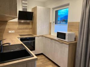 a small kitchen with a microwave and a window at Appartement Katrin in Bramberg am Wildkogel