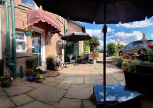 a patio with an umbrella in front of a building at Carisbrooke Guest House in Inverness +135 photos