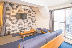 a living room with a blue couch and a tv at AMP FLAT Nishijin 3 in Fukuoka
