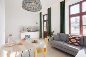 ein Wohnzimmer mit einem Tisch und einem Sofa in der Unterkunft Piotrkowska Welcome Apartments in Łódź