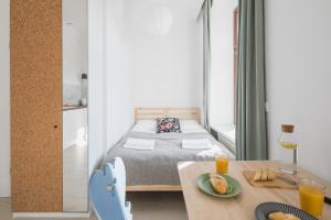 a bedroom with a bed and a table with food on it at Piotrkowska Welcome Apartments in Łódź