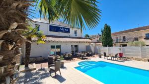 a hotel with a swimming pool in front of a building at ALYSA in Parthenay