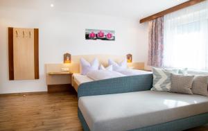 2 Betten in einem Zimmer mit Sofa und Fenster in der Unterkunft Haus Tirol in Kappl