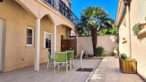 a patio with chairs and a table and a palm tree at ALYSA in Parthenay
